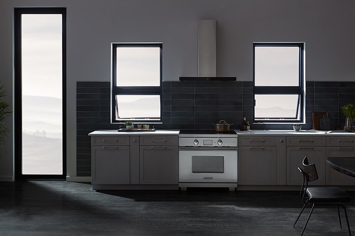 Modern dark gray kitchen with black tile backsplash and stainless steel appliances