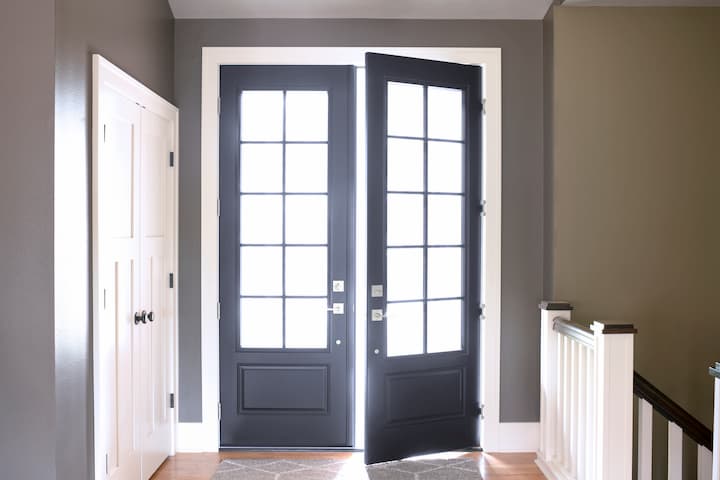 Modern entryway with black French doors and natural light in residential home