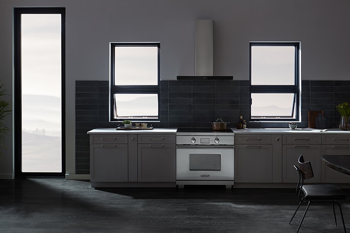 Modern dark gray kitchen with black tile backsplash and stainless steel appliances