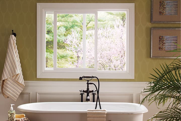 Luxury spa-style bathroom with freestanding tub and wisteria garden view