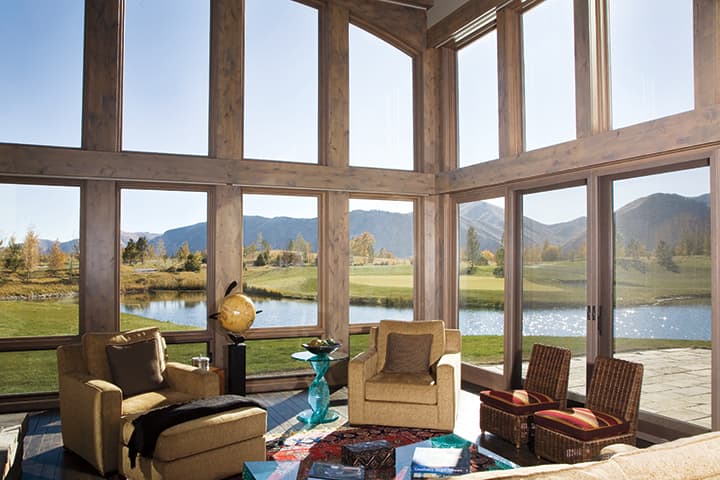 Luxurious sunroom with panoramic valley and mountain views through floor-to-ceiling windows