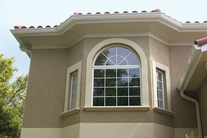 Modern residential home with curved bay window and tile roof architecture