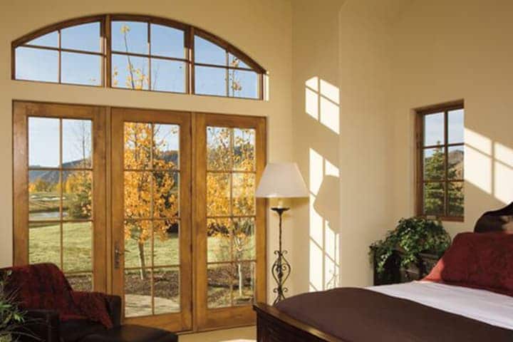 Luxury bedroom with French doors overlooking autumn landscape and mountains