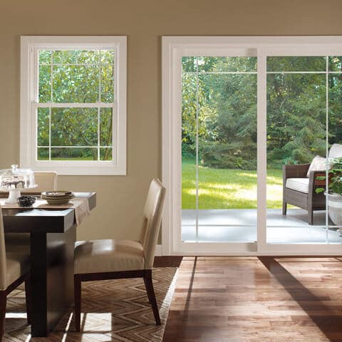Bright modern home office with large windows overlooking garden and green outdoor space