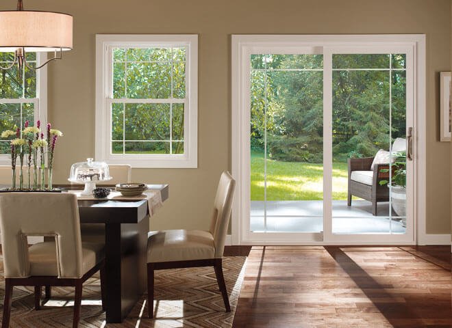 Modern dining room with patio doors overlooking landscaped backyard and garden view