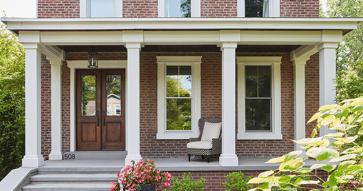 Classic brick home front porch with white columns and welcoming entryway