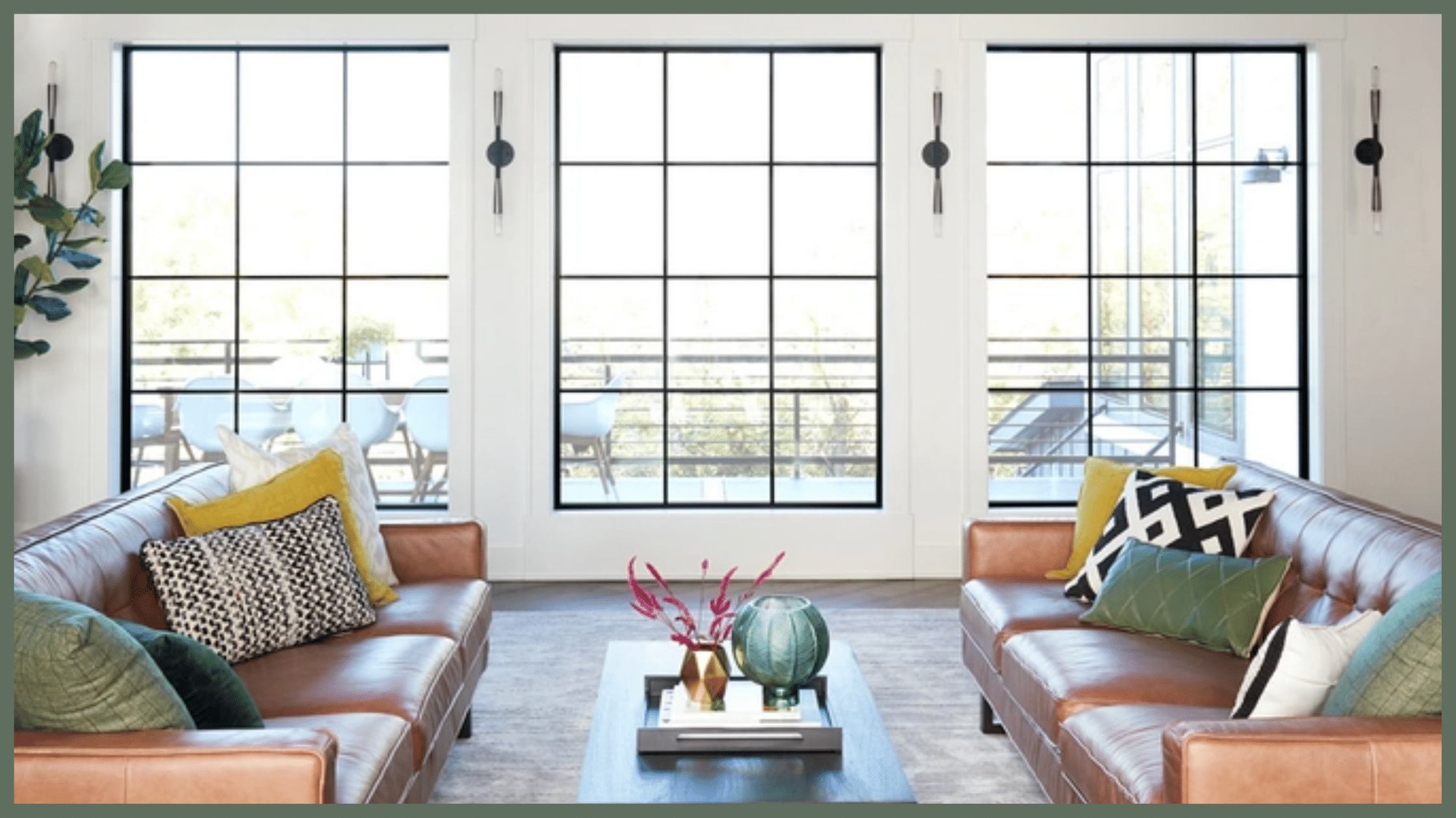 Modern living room with leather sofas and panoramic windows overlooking a terrace